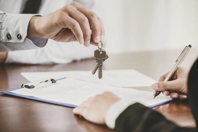 person handing keys over contract